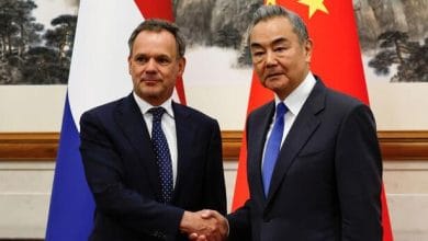 وزير الخارجية الصيني وانغ يي ووزير الخارجية الهولندي كاسبار فيلدكامب يتصافحان